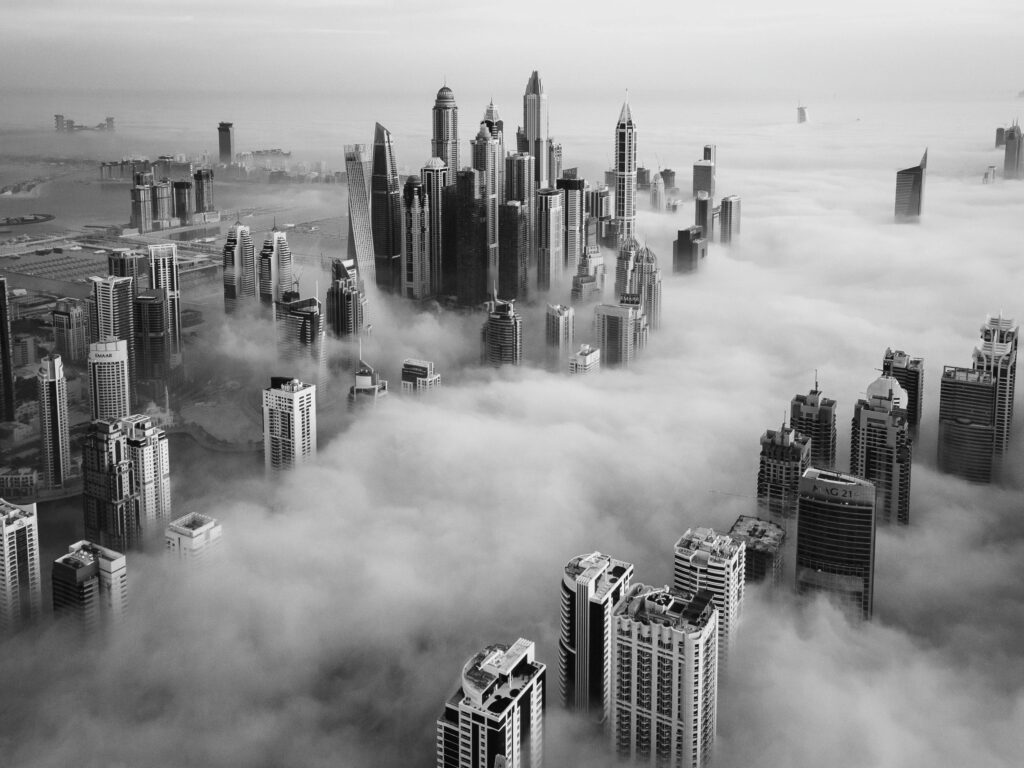 features Stunning black and white aerial view of fog enveloping Dubai's modern skyline.